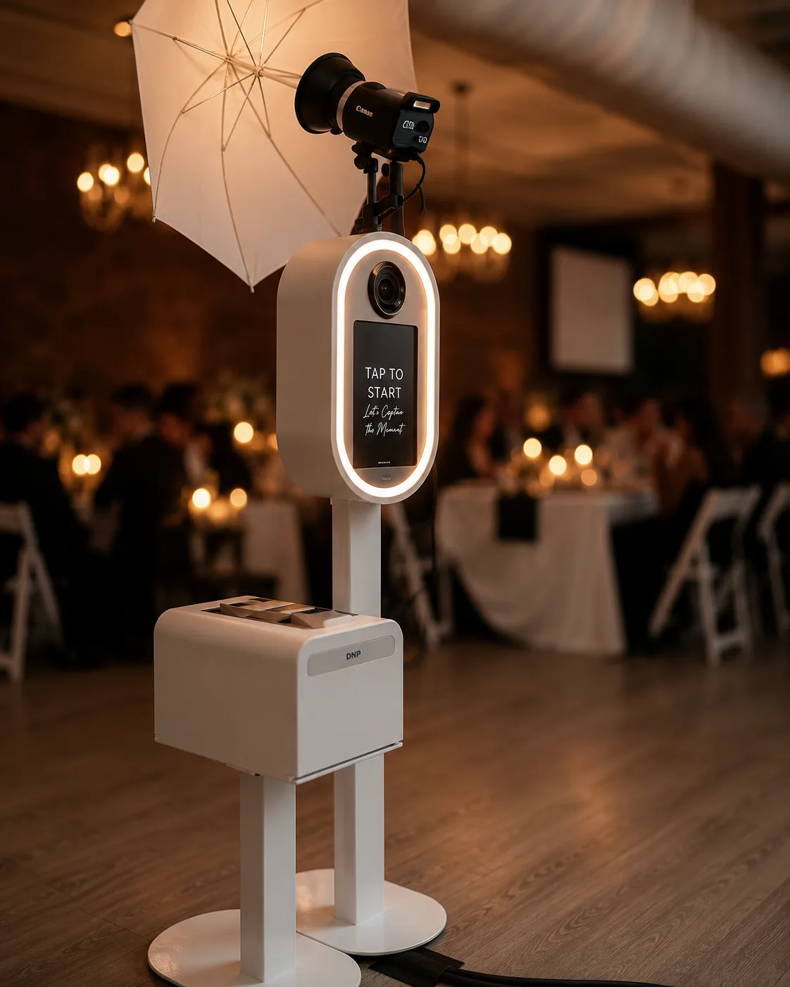 Canon EOS R100 detail on the open-air booth — gold ring light, blurred candlelight bokeh in the background